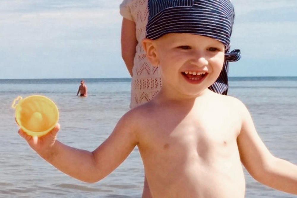Junge spielt im Sommer am Meer