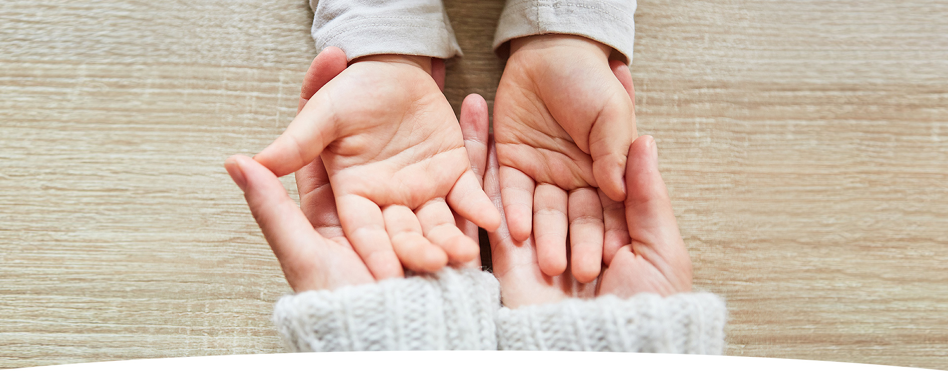 Erwachsenenhände halten Kinderhände